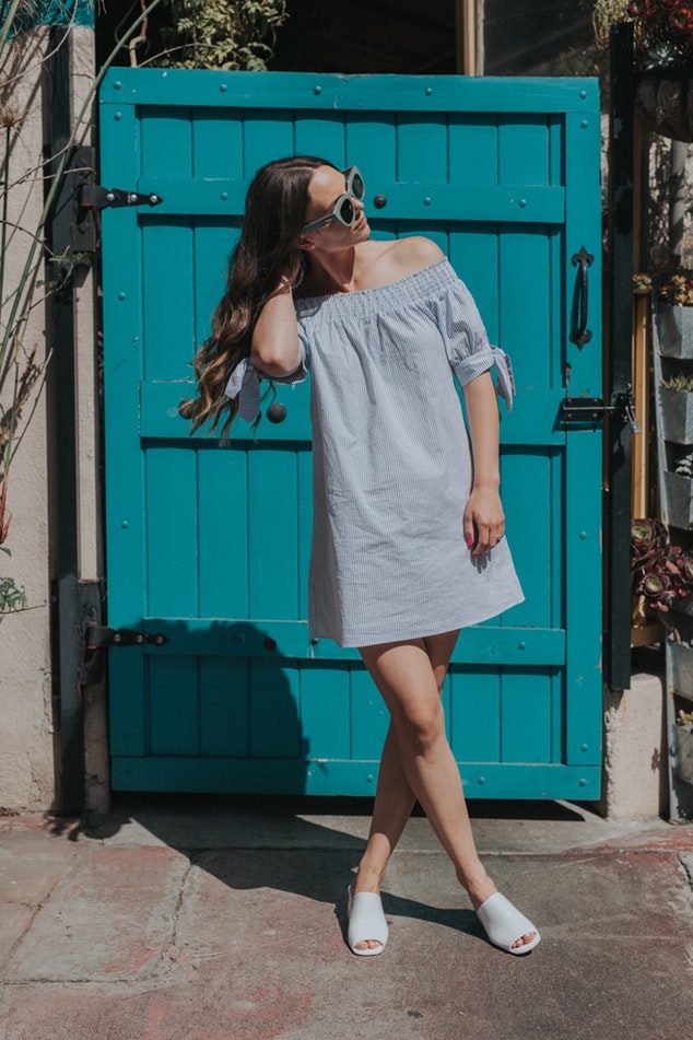 Young woman posing in front of blue door