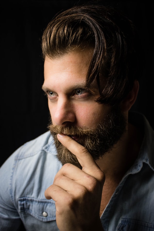 Young man with full beard deep in thought