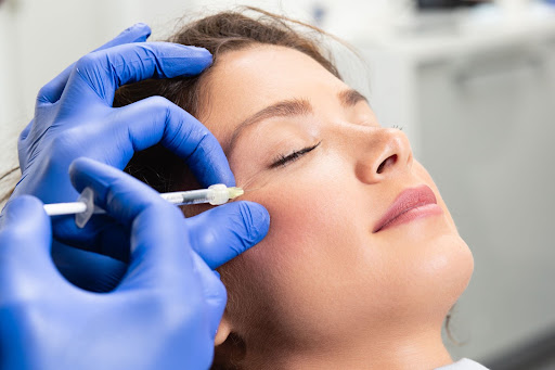 Woman receiving under eye filler treatment.
