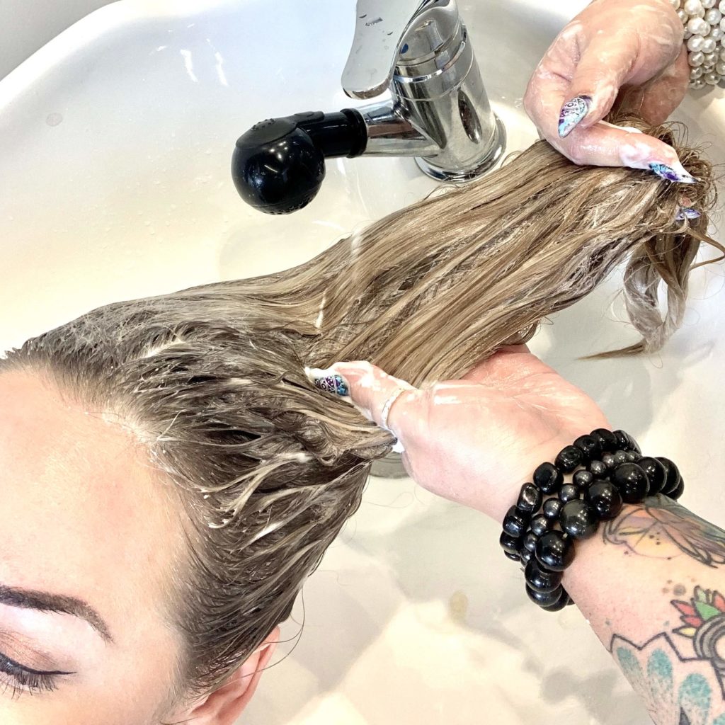 woman getting hair washed before cut
